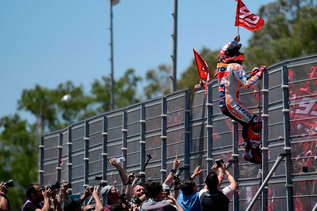 Marquez menaiki pagar penonton untuk menyapa penggemarnya setelah memenangi Moto-GP Spanyol.