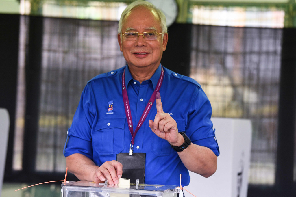 Usai menggunakan hak suaranya, PM Najib menunjukkan jarinya yang bertinta. AFP/MOHD RASFAN
