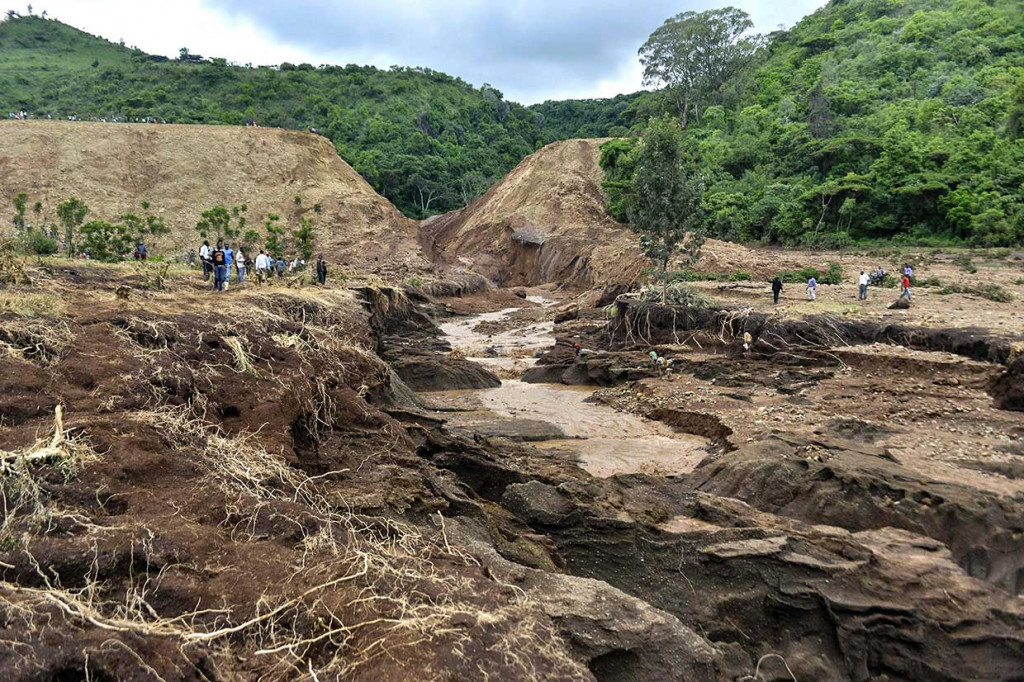 Warga melihat jebolnya bendungan Patel di bukit wilayah Nakuru, 190 kilometer barat laut Nairobi. Bendungan yang digunakan untuk irigasi dan peternakan ikan tersebut jebol pada Rabu, 9 Mei 2018 malam.