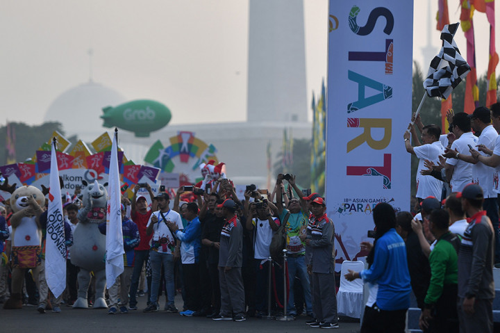Wakil Presiden Jusuf Kalla mengayunkan bendera start saat membuka Parade Asian Games 2018 di kawasan Monas, Jakarta. ANTARA/Sigid Kurniawan