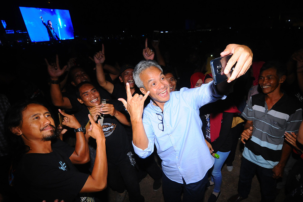 Calon Gubernur Jawa Tengah Ganjar Pranowo (tengah) berswafoto bersama sejumlah penonton dengan latar belakang panggung konser 