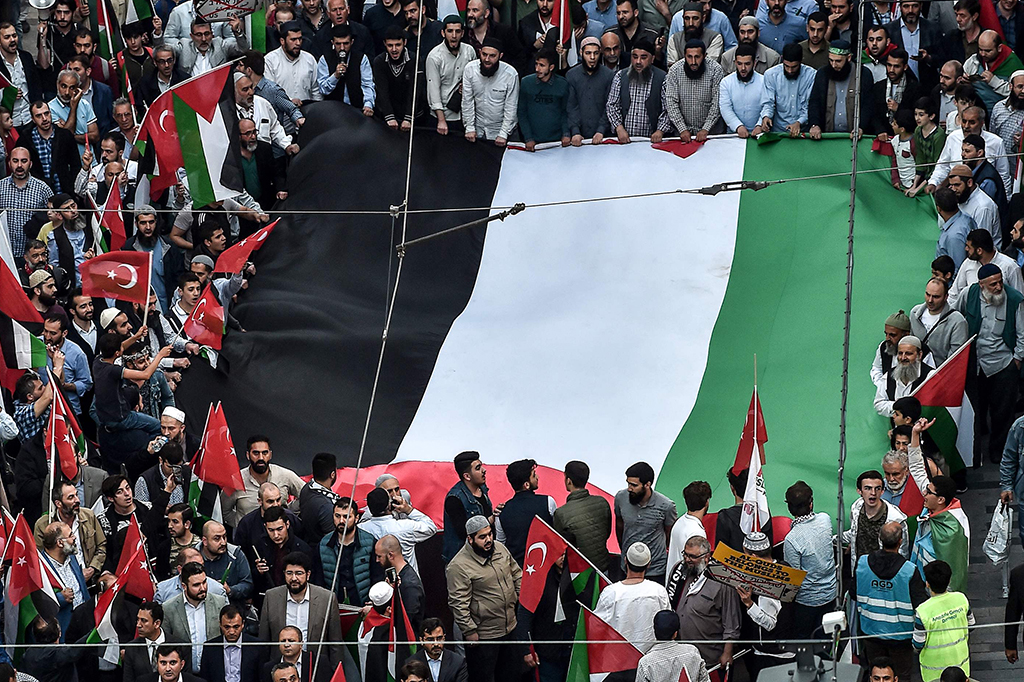Massa membentangkan bendera Palestina berukuran raksasa. AFP/OZAN KOSE
