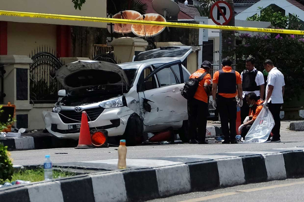 Petugas kepolisian memeriksa mobil Avanza yang digunakan para terduga teroris saat berupaya menyerang Markas Polda Riau, Rabu, 16 Mei 2018. AFP/Dedy Sutisna