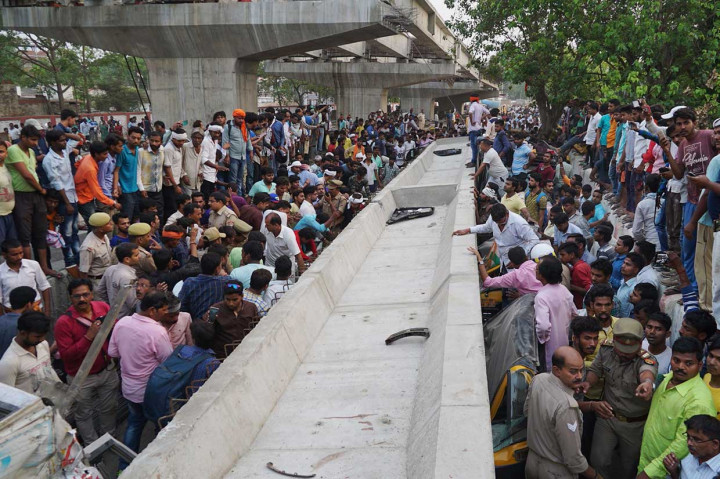 Petugas penyelamat dibantu warga berusaha mengevakuasi para korban yang terperangkap di dalam mobil yang tertimpa bongkahan beton konstruksi jembatan layang di Varanasi, sebuah kota di Negara Bagian Uttar Prades, Rabu, 16 Mei 2018.