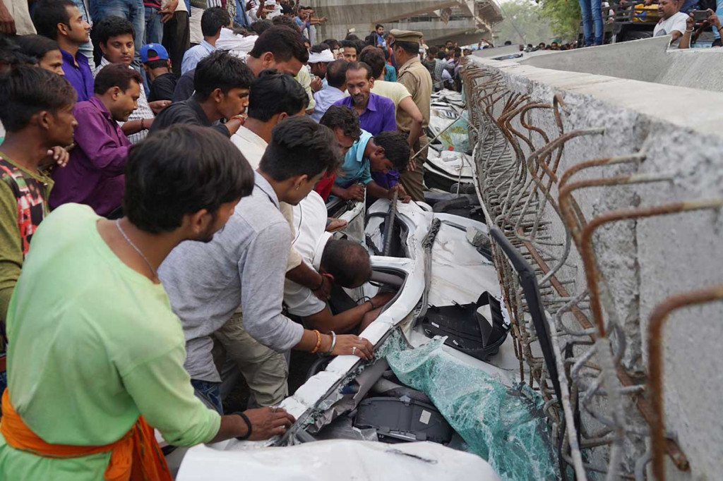 Setidaknya empat mobil, sebuah becak, dan sebuah minibus tertimpa bongkahan beton konstruksi jembatan layang di Varanasi.