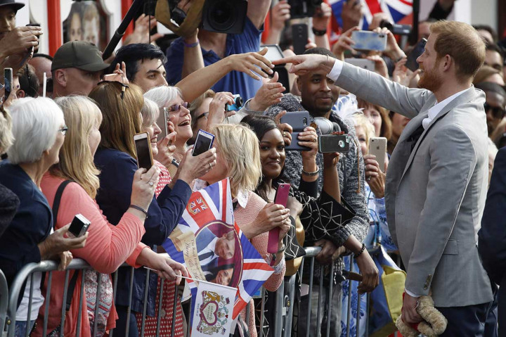 Pangeran Harry menyapa warga yang antusias menunggu prosesi pernikahannya di luar Kastil Windsor, Winsor, Jumat, 18 Mei 2018 waktu setempat. Pangeran Harry akan melangsungkan pernikahan dengan Meghan Markle di Kastil Windsor, Sabtu, 19 Mei 2018 siang waktu setempat.
