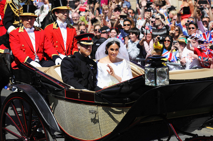 Meghan Markle tampil memesona dengan balutan gaun pengantin putih rancangan desainer Clare Waight Keller dari Givenchy. Dan Harry tampil dengan seragam militer miliknya yaitu Household Cavalry. AFP PHOTO / POOL / Christopher Furlong