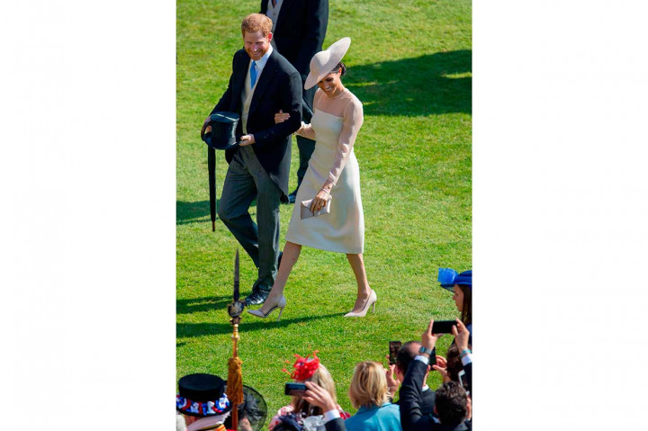 Pengantin baru Pangeran Harry dan Meghan Markle tersenyum saat menyapa warga yang hadir pada pesta perayaan ulang tahun ke-70 Pangeran Charles di Istana Buckingham, Selasa, 22 Mei 2018 waktu setempat.