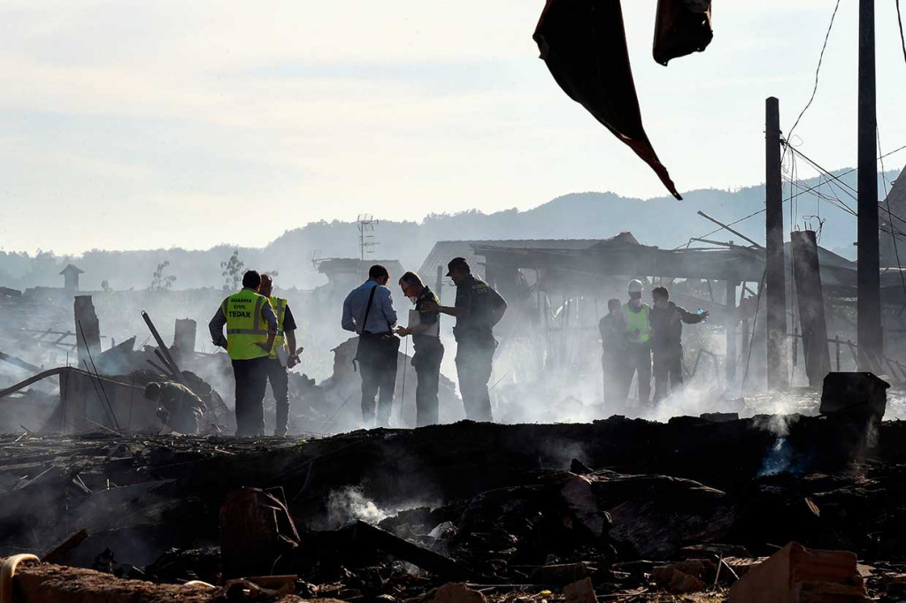 Petugas melakukan penyelidikan di antara reruntuhan bangunan rumah pascaledakan petasan di tempat penyimpanan petasan di Kota Tui, Galicia, kawasan utara Spanyol, Rabu, 23 Mei 2018 waktu setempat.