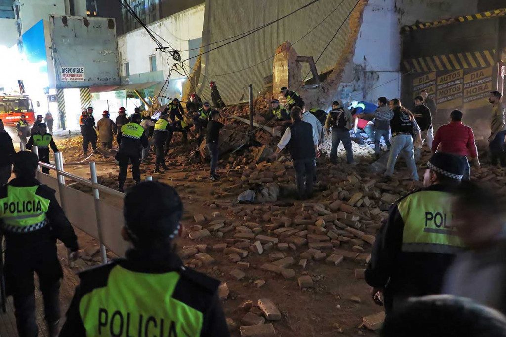 Polisi dan petugas pemadam kebakaran mencari korban di antara puing-puing beberapa menit setelah runtuhnya gedung bioskop lama Parravicini, di Tucuman.