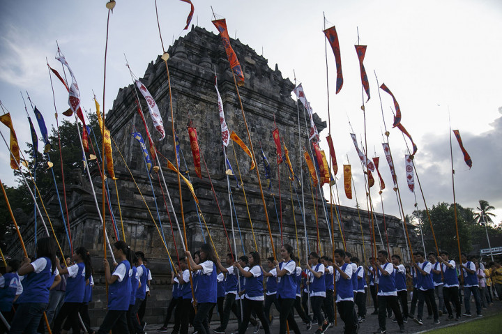 Mereka lalu menuju ke tenda di pelataran Candi Mendut untuk menyalakan lilin pancawarna. Di depan altar besar dengan patung Sang Buddha dan hiasan aneka bunga dan buah-buahan di tenda itu, secara bergantian mereka membacakan parita atau doa-doa dalam ajaran Buddha.
