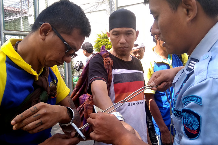 Mereka diborgol lalu dibawa menggunakan dua mobil melewati dua pintu.