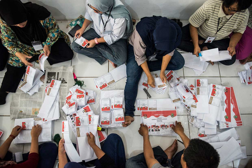 Petugas melipat dan menyortir surat suara Pemilihan Gubernur Jabar 2018 di GOR STT Mandala, Bandung, Jawa Barat, Rabu, 30 Mei 2018.