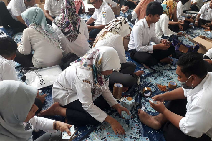 Pegawai Ditjen Dukcapil Kemendagri menggunting bagian KTP-el yang rusak saat pemusnahan di Gudang Aset Kemendagri, jalan raya Parung, Kemang, Kabupaten Bogor. MI/Dede Susianti