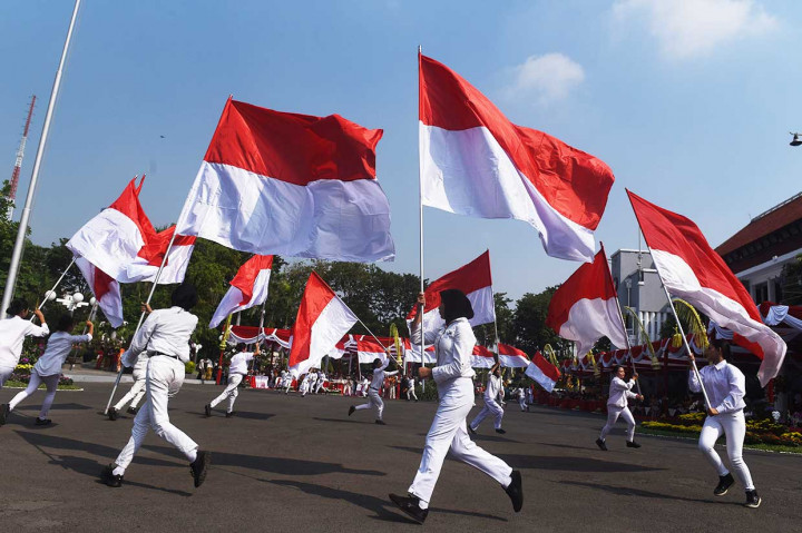 Sejumlah pelajar membawa bendera merah putih saat upacara hari jadi Kota Surabaya yang ke-725.