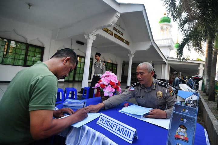 Petugas kepolisian melayani warga yang memperpanjang masa berlaku SIM-nya di halaman Masjid Hikmatul Ilmi, Kramat Jati, Jakarta Timur, Jumat, 1 Juni 2018. 