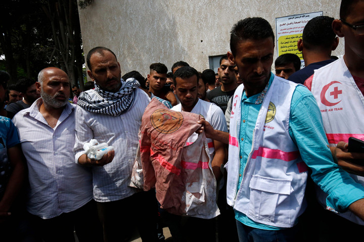 Kru ambulan dan medis berdatangan menghadiri pemakaman. Ayah Razan memegang baju medis bernoda darah yang dikenakan anaknya saat tertembak. AFP/SAID KHATIB