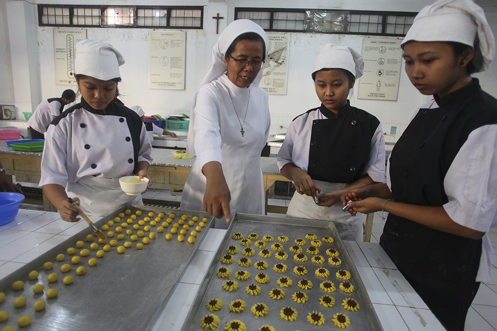 Siswa Jurusan Tata Boga SMK Marsudirini Marganingsih Solo membuat pesanan kue kering di sekolah setempat, Solo, Jawa tengah. Menurut pihak sekolah, produksi kue kering untuk kebutuhan lebaran seperti kue nastar dan kue kastengel, yang dijual seharga Rp18 ribu hingga Rp35 ribu tergantung ukuran tersebut banyak diminati masyarakat dan hanya membatasi pemesanan hingga H-7 lebaran. Antara Foto/Maulana Surya
