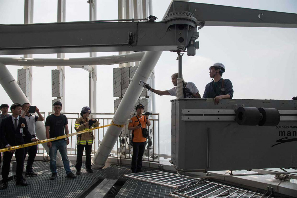 Sang Spiderman kemudian ditarik ke puncak gedung dengan gondola dan diamankan aparat kepolisian.