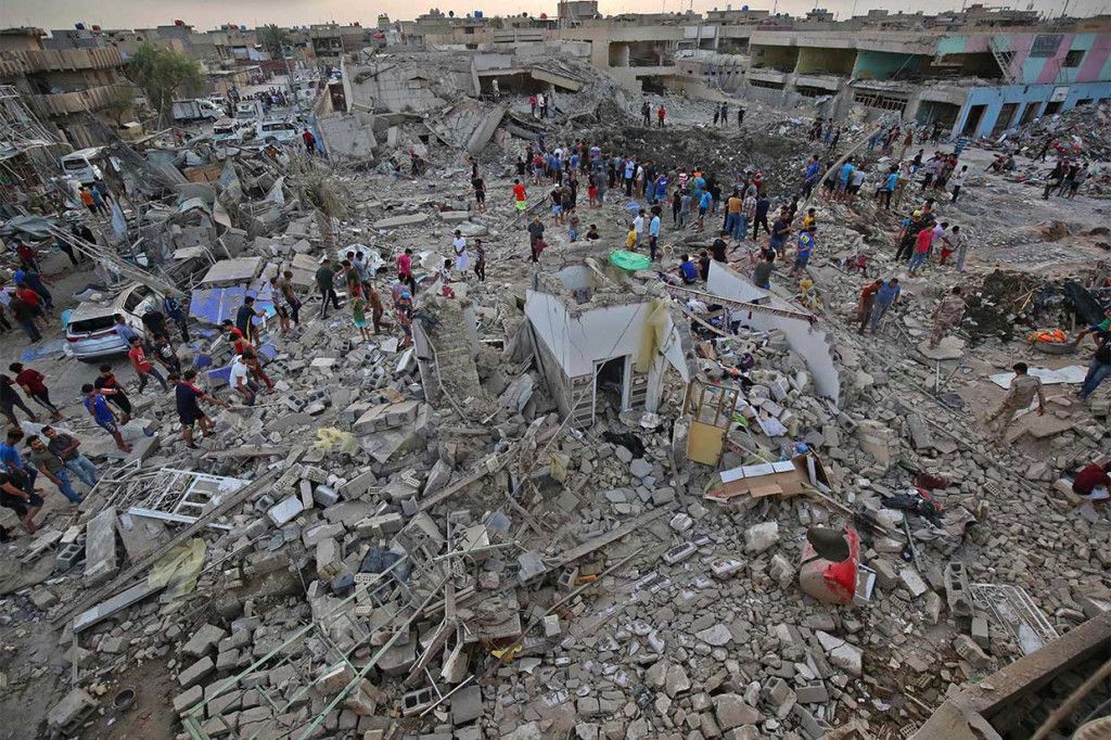 Warga melihat kerusakan yang terjadi setelah sebuah depot senjata di Distrik Sadr City, Baghdad, meledak, Kamis, 7 Juni 2018.