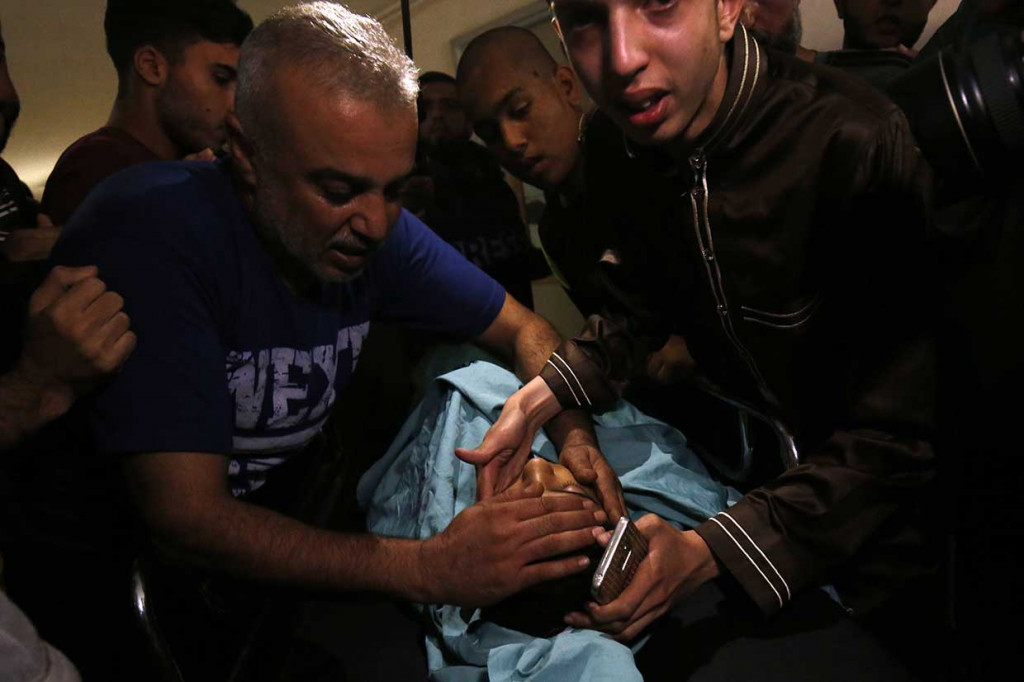 Kerabat berduka saat melihat jenazah Haitham al-Jamal di kamar mayat rumah sakit di Khan Yunis di Jalur Gaza, Jumat, 8 Juni 2018 waktu setempat. Haitham termasuk dari empat warga Palestina yang tewas ditembak tentara Israel selama bentrokan di sepanjang perbatasan antara Gaza dan Israel, Jumat.