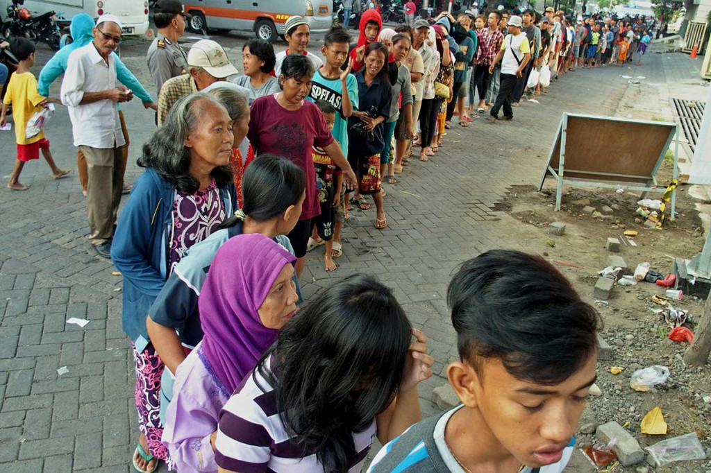 Ratusan warga antre saat pembagian zakat dalam bentuk uang yang dibagikan oleh keluarga besar Muhammad Nawang Layung, di Kawasan Kota Lama Semarang, Jawa Tengah, Minggu, 10 Juni 2018.