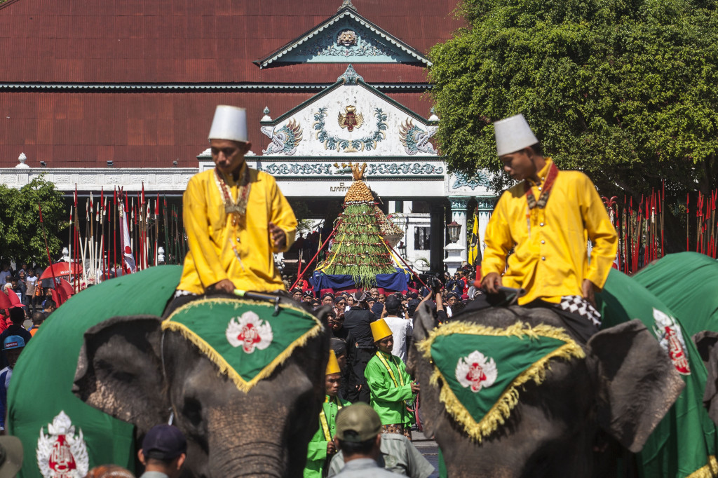Sepasang gajah dikendalikan abdi dalem Keraton Yogyakarta mengikuti prosesi adat Grebeg Syawal 1439 H. 
