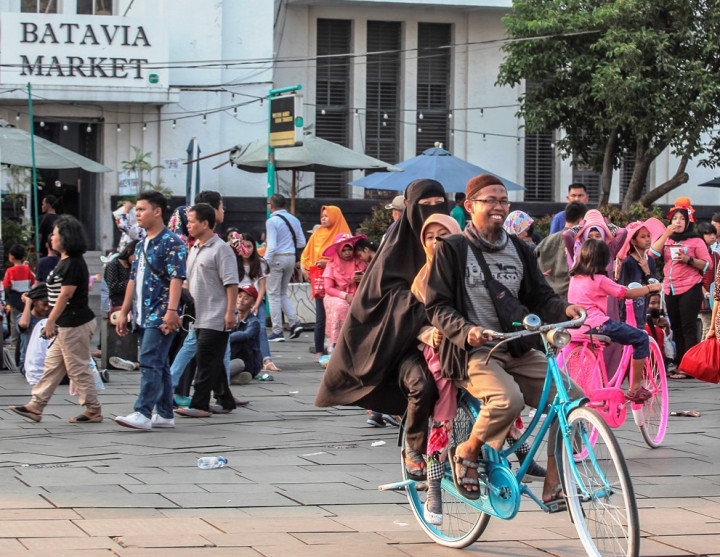 Keluarga berboncengan sepeda tua sewaan di pelataran Museum Fatahillah, Jakarta. Kawasan Kota Tua yang sudah tertata semakin jadi pilihan wisata murah meriah bagi warga Jakarta. 