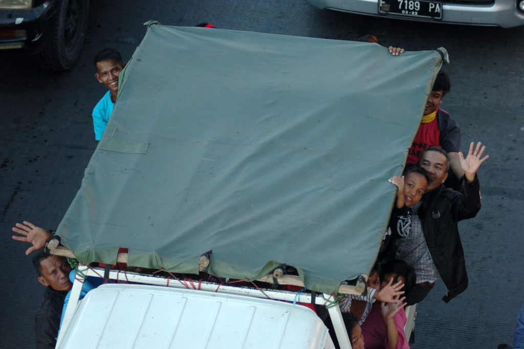 Sebuah mobil bak terbuka mengangkut pemudik melintas di Jalur Pantura, Tegal. Meskipun telah dilarang, tapi masih banyak pemudik nekat menumpang kendaraan bak terbuka. 