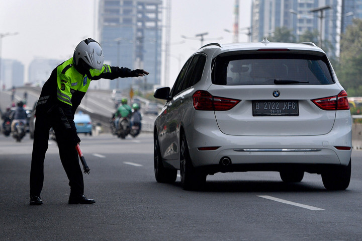 Relawan penyapu ranjau paku Saber Community, Rohim mencari ranjau paku di kawasan Jalan Gatot Subroto.