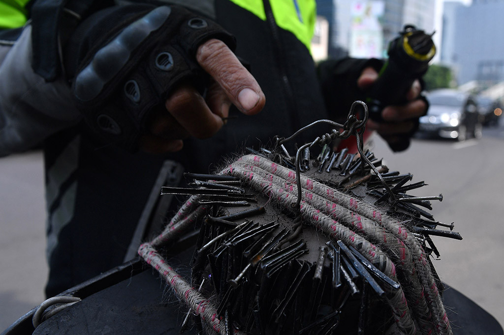 Relawan penyapu ranjau paku Saber Community, Rohim menunjukkan ranjau paku yang berhasil dikumpulkan di kawasan Jalan Gatot Subroto, Jakarta.