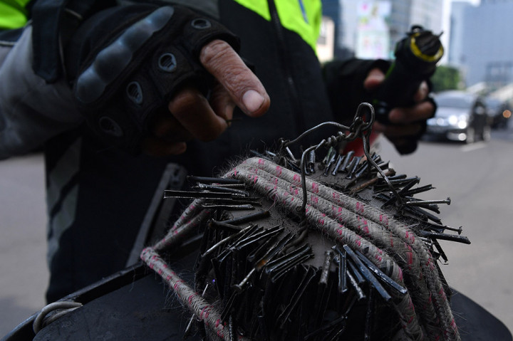 Relawan penyapu ranjau paku Saber Community, Rohim menunjukkan ranjau paku yang berhasil dikumpulkan di kawasan Jalan Gatot Subroto, Jakarta.