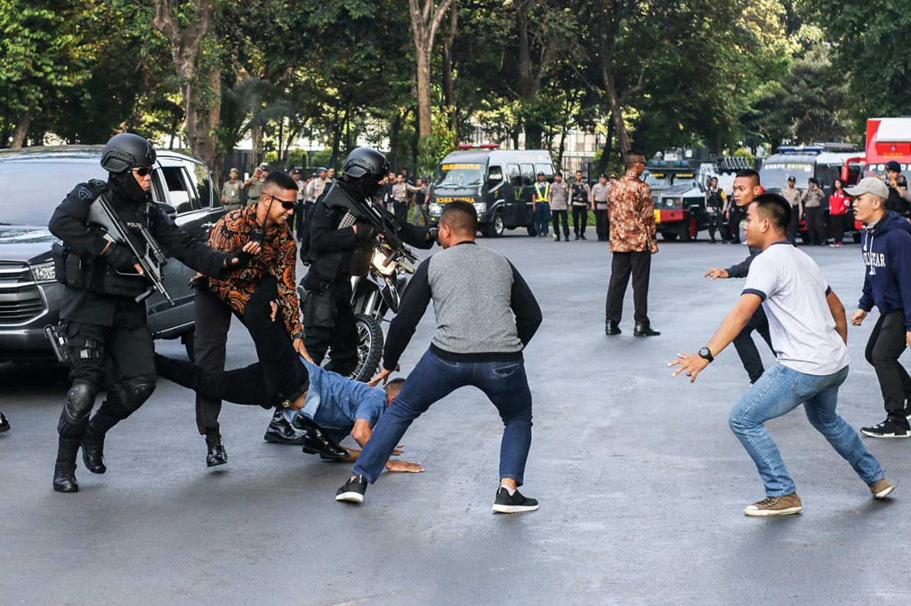 Petugas kepolisian menangkap seorang perusuh pada simulasi pengamanan Asian Para Games 2018 di Kompleks Gelora Bung Karno, Jakarta.