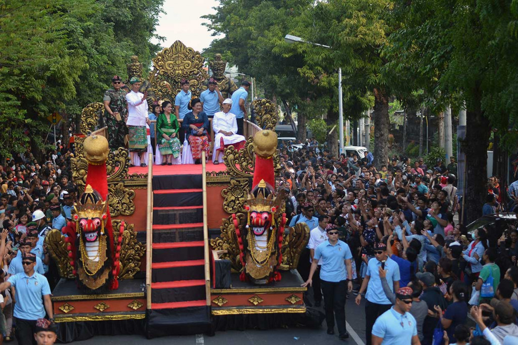 Presiden Joko Widodo (kiri) didampingi Ibu Negara Iriana Joko Widodo (kedua kiri), Gubernur Bali I Made Mangku Pastika (kanan) dan istri Ni Made Ayu Putri mengikuti Pawai Pesta Kesenian Bali ke-40 di Denpasar, Bali, Sabtu, 23 Juni 2018. Antara Foto/Wahyu Putro A
