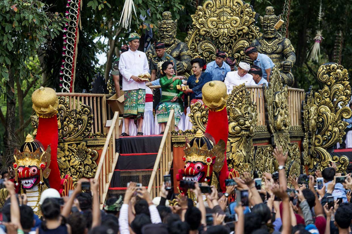 Presiden Jokowi didampingi Ny Iriana dan Gubernru Bali I Made Mangku Pastika dan istri menyapa masyarakat sambil membagikan buku dan kain batik. Antara Foto/Ismar Patrizki