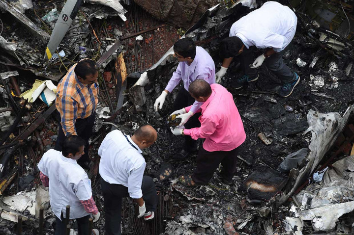 Petugas investigasi tengah melakukan penyelidikan di tempat kejadian jatuhnya pesawat ringan di lokasi konstruksi di Mumbai, India, Kamis, 28 Juni 2018.