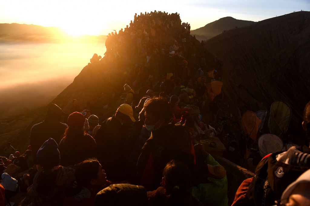 Wisatawan dan masyarakat suku Tengger mengikuti Upacara Yadnya Kasada di bibir kawah Gunung Bromo, Probolinggo, Jawa Timur.