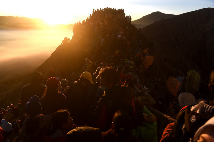 Wisatawan dan masyarakat suku Tengger mengikuti Upacara Yadnya Kasada di bibir kawah Gunung Bromo, Probolinggo, Jawa Timur.