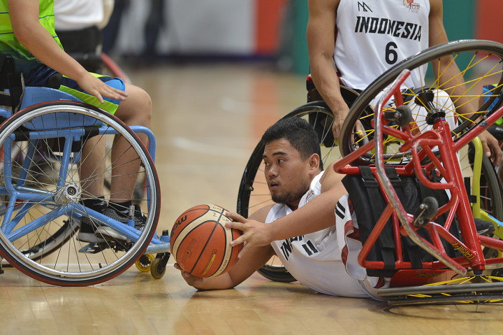 Pebasket kursi roda Indonesia Kasep Ayatulloh terjatuh ketika berebut bola dengan atlet Malaysia pada Indonesia Para Games Invitational Tournament di Kompleks Gelora Bung Karno, Senayan, Jakarta.