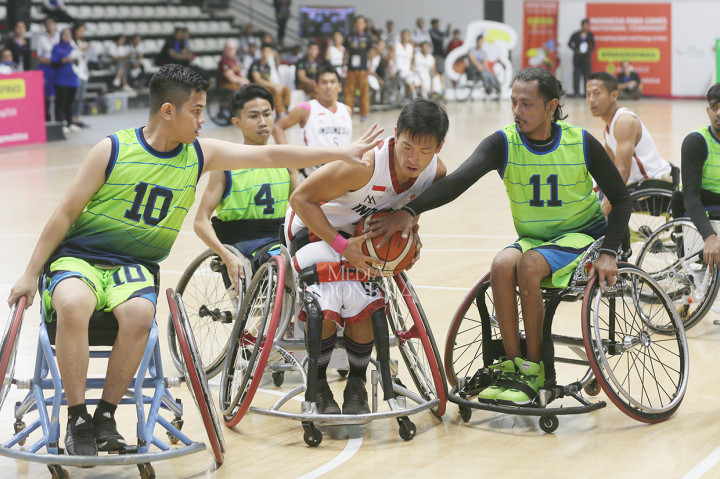 Pebasket disabel Indonesia Donald Putra Santoso (kanan) berusaha melewati hadangan pebasket disabel Malaysia pada pertandingan bola basket Para Games Invitational Tournament di Hall Basket Gelora Bung Karno, Jakarta.
