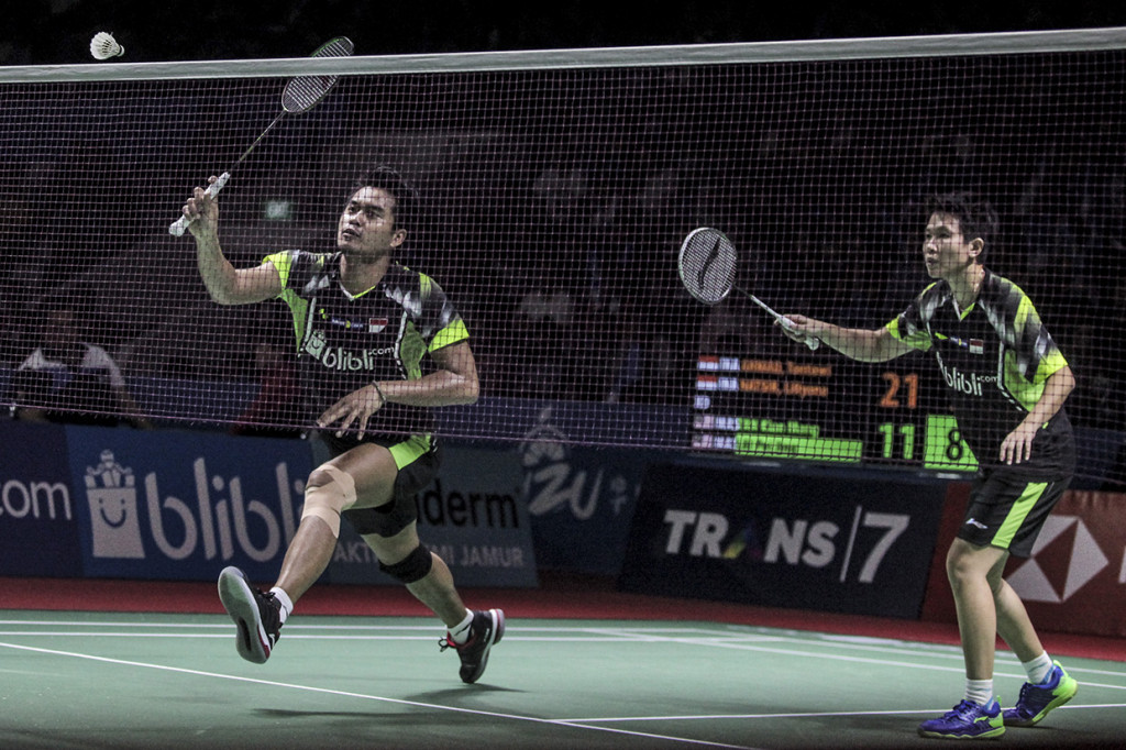 Pebulu tangkis ganda campuran Indonesia Tontowi Ahmad  dan Liliyana Natsir melakukan servis ke arah lawannya pasangan Malaysia Tan Kian Meng dan Lai Pei Jing pada babak pertama Turnamen Bulu Tangkis Blibli Indonesian Open 2018 di Istora Senayan. Antara Foto/Muhammad Adimaja