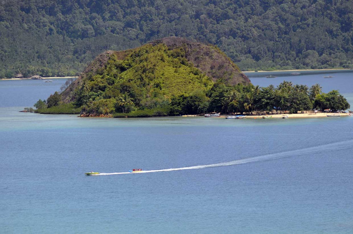Wisatawan menaiki perahu pisang di depan Pulau Setan, KWBT Mandeh, Kabupaten Pesisir Selatan.
