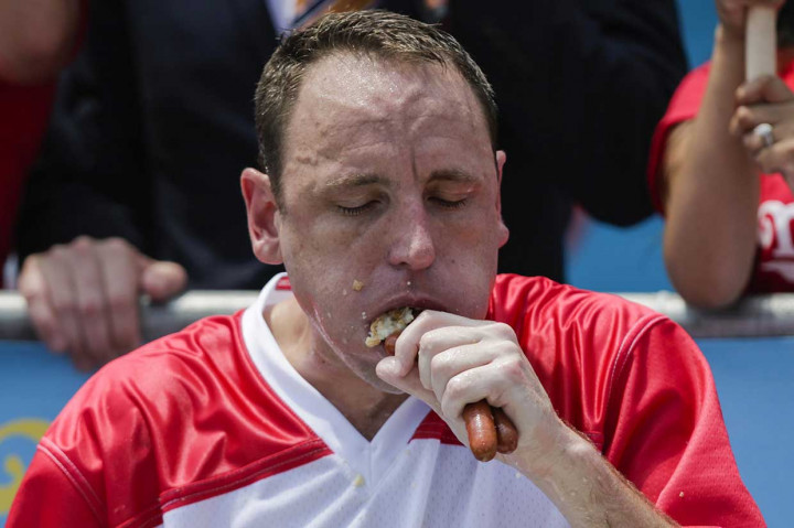 Seorang pria AS, Joey Chestnut berusaha melahap hot dog dalam kontes tahunan Nathan's Famous Hot Dog Eating Contest di Coney Island, New York, Rabu, 4 Juli 2018 waktu setempat.