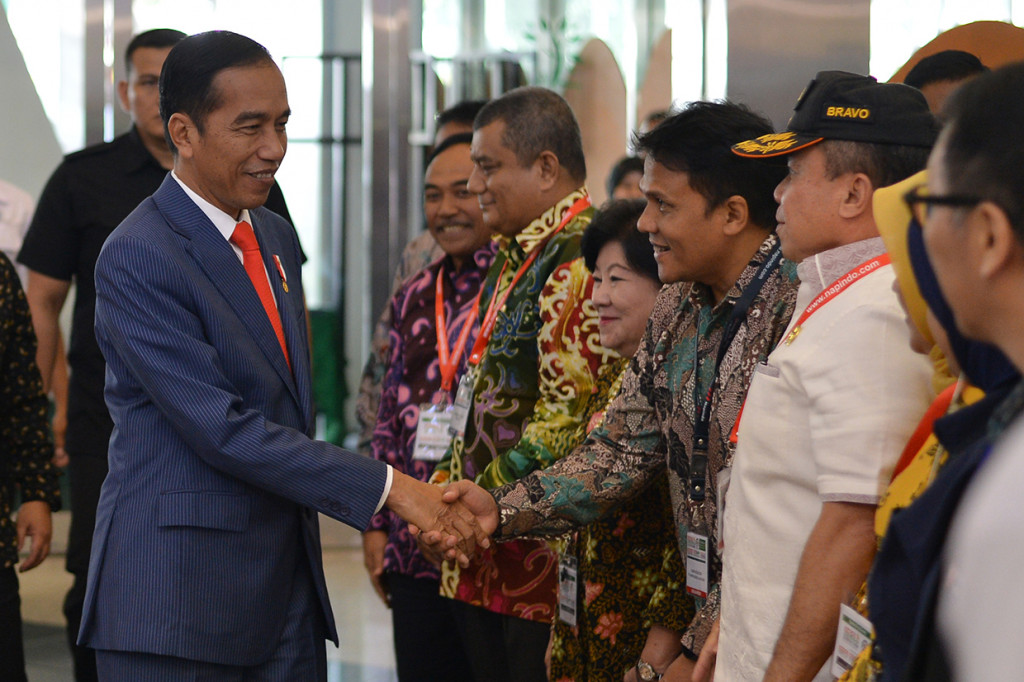 Presiden Joko Widodo (kiri) menyalami pengunjung ketika meninjau pameran dan forum Indo Livestock 2018 di JCC, Senayan, Jakarta. 