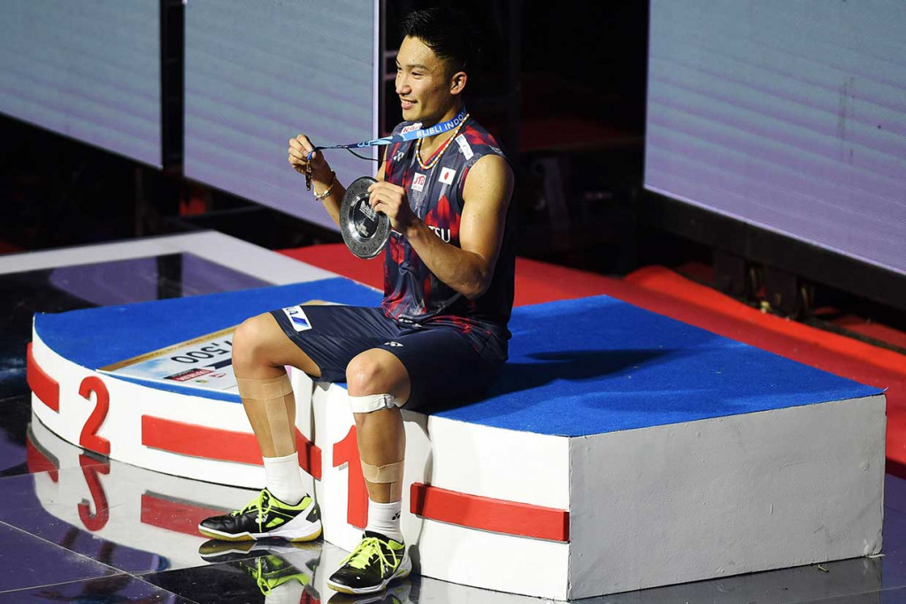 Pebulu tangkis tunggal putera Jepang Kento Momota menunjukkan piala dan medali usai menang atas pebulu tangkis Denmark Viktor Axelsen dalam partai final Blibli Indonesia Open 2018 di Jakarta, Minggu (8/7). Antara Foto/Akbar Nugroho Gumay