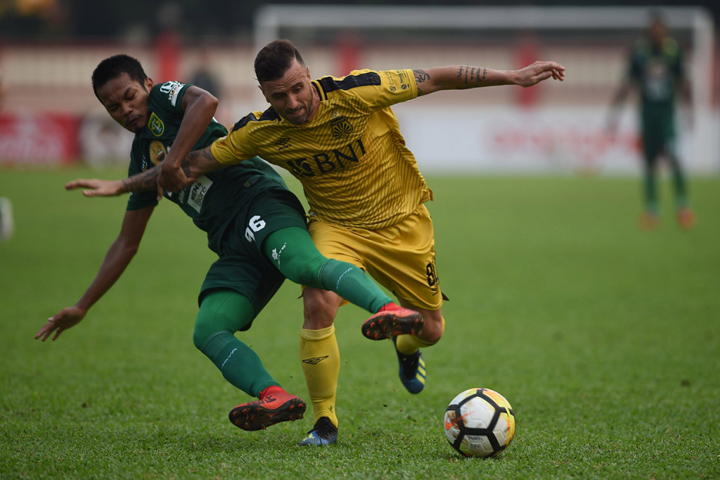 Pesepak bola Persebaya Surabaya Muhammad Hidayat (kiri) berebut bola dengan pesepak bola Bhayangkara FC Paulo Sergio (kanan) dalam laga lanjutan Liga 1 di Stadion PTIK, Jakarta. Pertandingan tersebut berakhir imbang 3-3.
