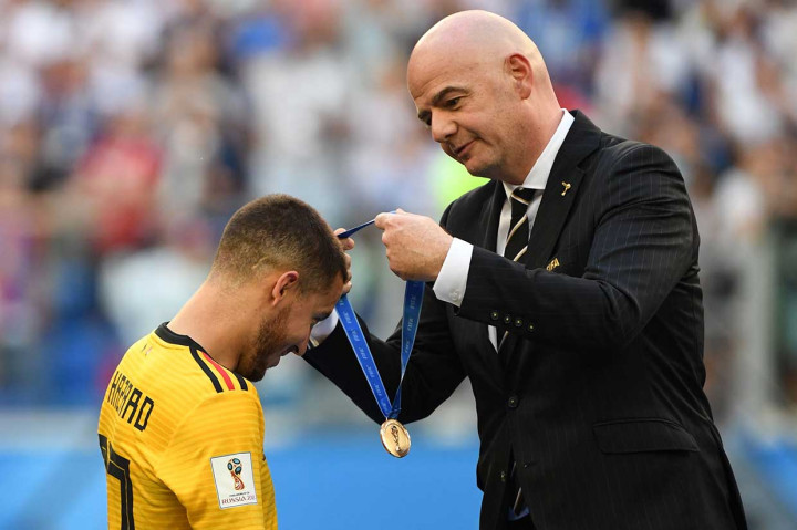 Kapten tim Belgia Eden Hazard mendapat pengalungan medali perunggu dari Presiden FIFA Gianni Infantino usai meriah peringkat ketiga Piala Dunia 2018.