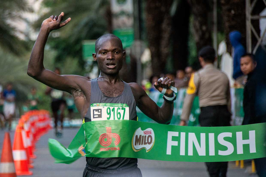 Pelari asal Kenya David Kibet menyentuh garis finis pertama lomba lari Milo Jakarta International 10K di Kawasan Rasuna Epicentrum, Jakarta, Minggu, 15 Juli 2018. 