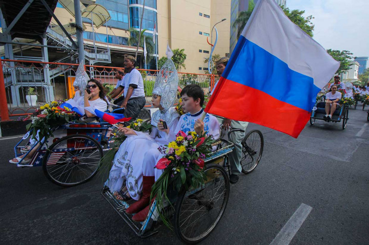 Peserta parade lintas budaya mengikuti pawai becak di Surabaya. Kegiatan itu merupakan rangkaian Surabaya Cross Culture International Folk and Art Festival 2018 yang diikuti oleh 10 negara dan tiga kota dari Indonesia. 