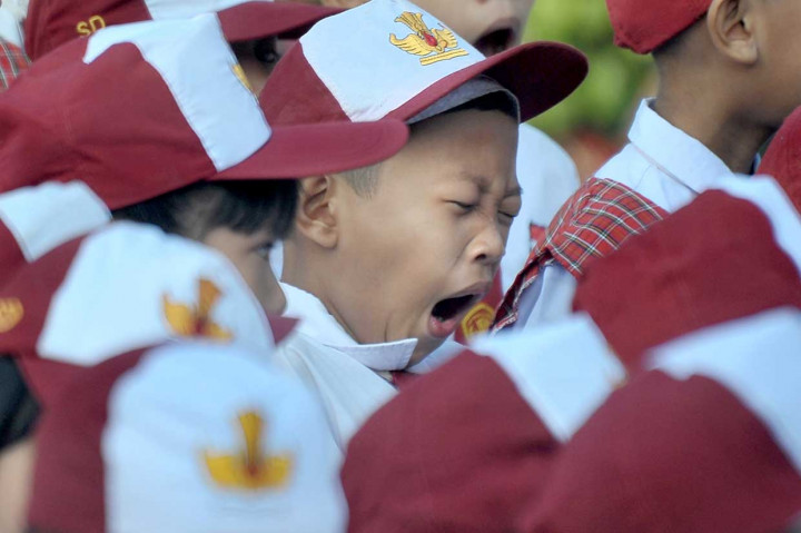 Salah satu siswa menguap di sela upacara bendera pada hari pertama masuk sekolah di Sekolah Dasar Negeri (SDN) 243 Palembang, Sumatera Selatan. Antara Foto/Feny Selly